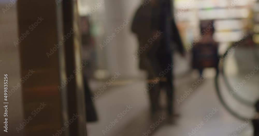 Close up blur shot of people walking in the mall. Abstract Defocused Blurred Background flow of many people inside space shopping center or mall, exhibition, exposition, hall real time. Close up blur shot of people walking in the mall. Abstract Defocused Blurred Background flow of many people inside space shopping center or mall, exhibition, exposition, hall real time.