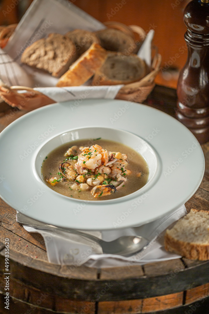 Seafood Soup on White Plate with Bread, Restaurant food Seafood Soup on White Plate with Bread, Restaurant food
