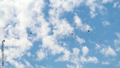 Parachutes in front of the clouds at Manali in Himachal Pradesh, India. Tourists enjoying paragliding experience at Manali. People enjoying the paragliding experience at Manali	 photo