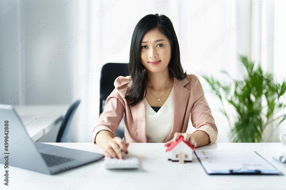 Entrepreneurs, business owners, accountants, real estate agents, Portrait of asian woman uses a calculator to calculate her home budget to assess the risks of investing in real estate. Entrepreneurs, business owners, accountants, real estate agents, Portrait of asian woman uses a calculator to calculate her home budget to assess the risks of investing in real estate.