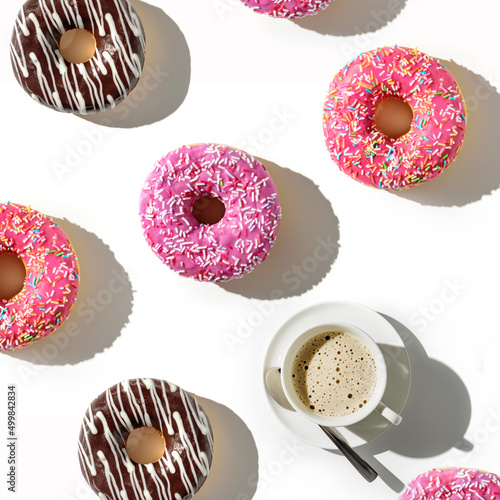 A cup of coffee and a variety of donuts on a white background. Flat lay composition with coffee and donuts.
