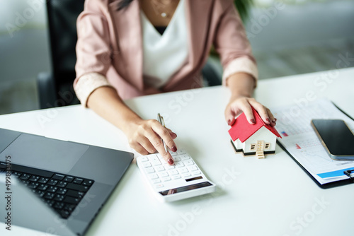 Entrepreneurs, business owners, accountants, real estate agents, A young woman uses a calculator to calculate her home budget to assess the risks of investing in real estate.