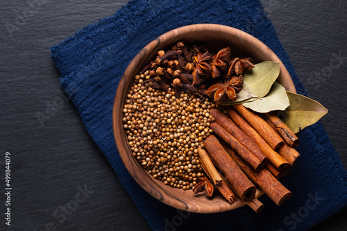 Food ingredient Thai Five Spice in wooden bowl on black slate stone board with copy space photo