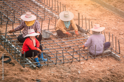 Thai workers hands using iron wire for securing iron bars . 