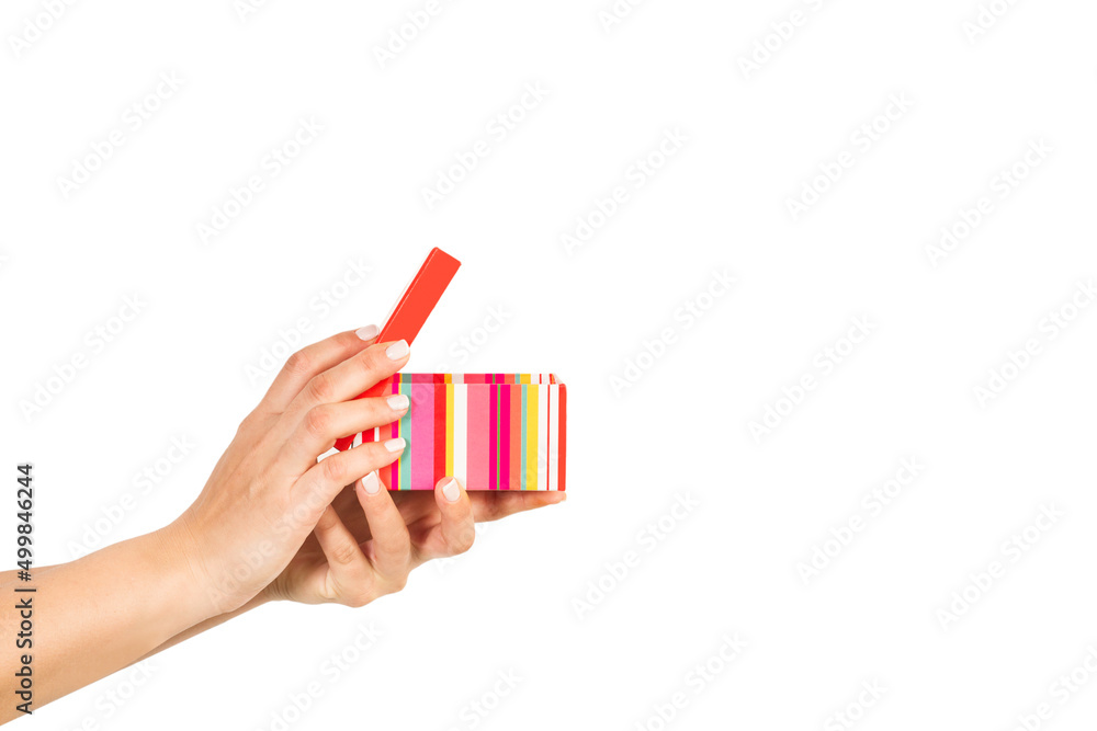 Mano de mujer sosteniendo una caja de cartón a rayas de colores con la tapa levantada sobre un fondo blanco liso y aislado. Vista de frente y de cerca. Copy space Mano de mujer sosteniendo una caja de cartón a rayas de colores con la tapa levantada sobre un fondo blanco liso y aislado. Vista de frente y de cerca. Copy space