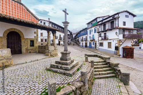 Village square with stone cross and mountain views in the village of Candelario, Salamanca, Spain. photo