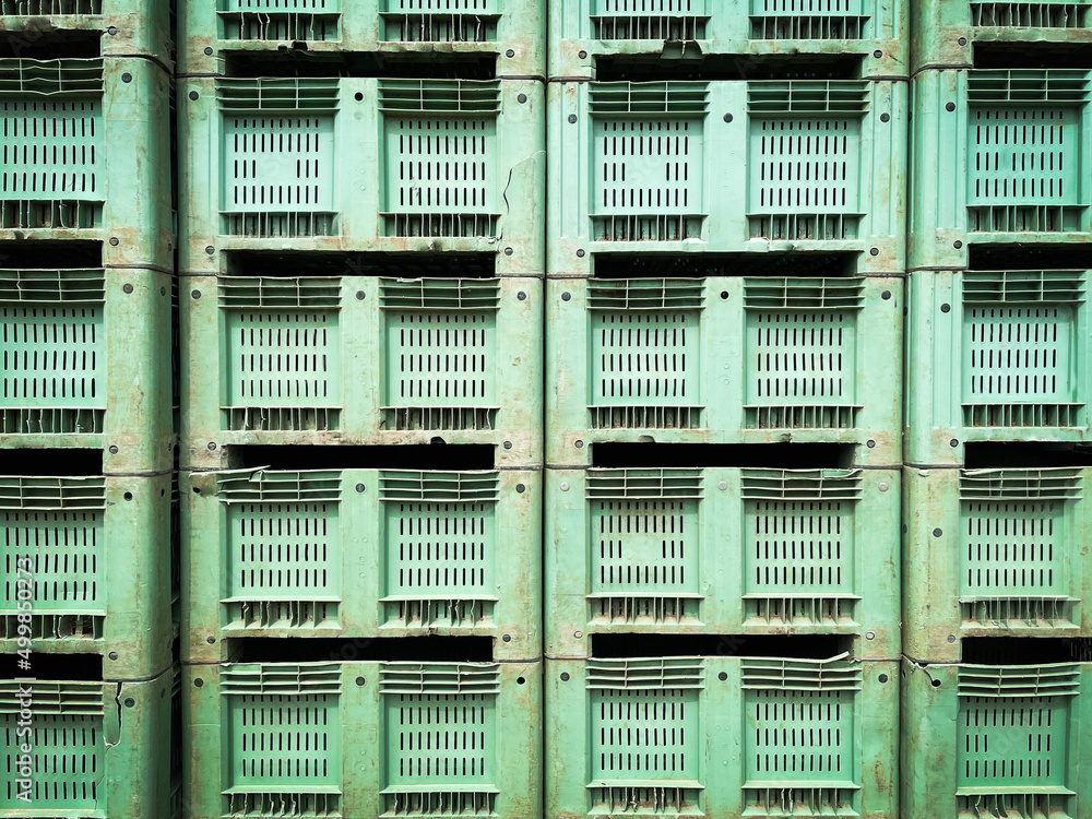 Stack of green color old and damaged used plastic packaging crates background. Stack of green color old and damaged used plastic packaging crates background.