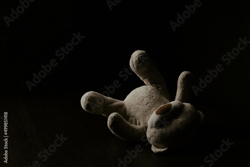 Teddy bear laying down alone at night. Lonely concept, international missing children's day