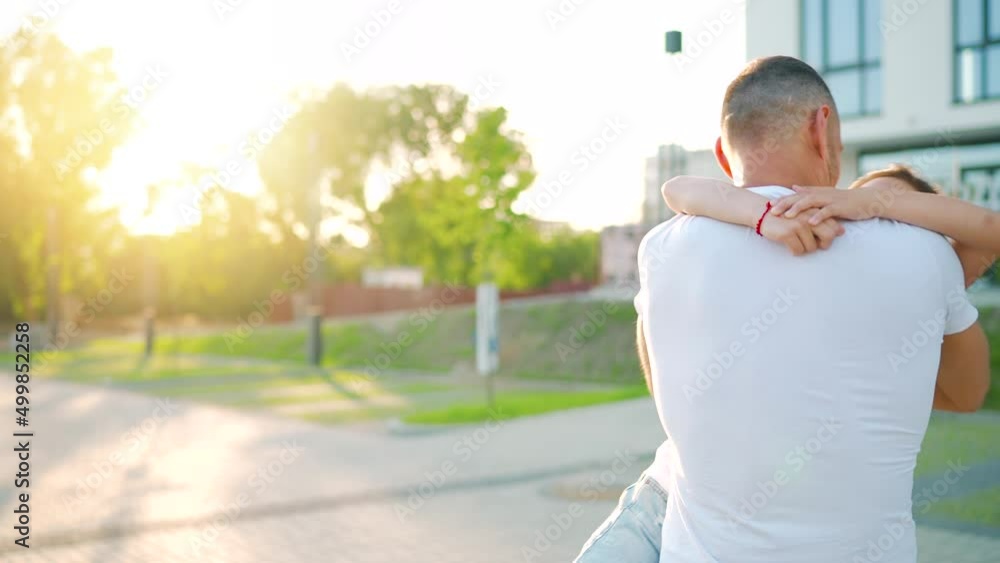 Daughter runs to dad and hugs him. Father picks up the child in his arms. Slow motion Daughter runs to dad and hugs him. Father picks up the child in his arms. Slow motion