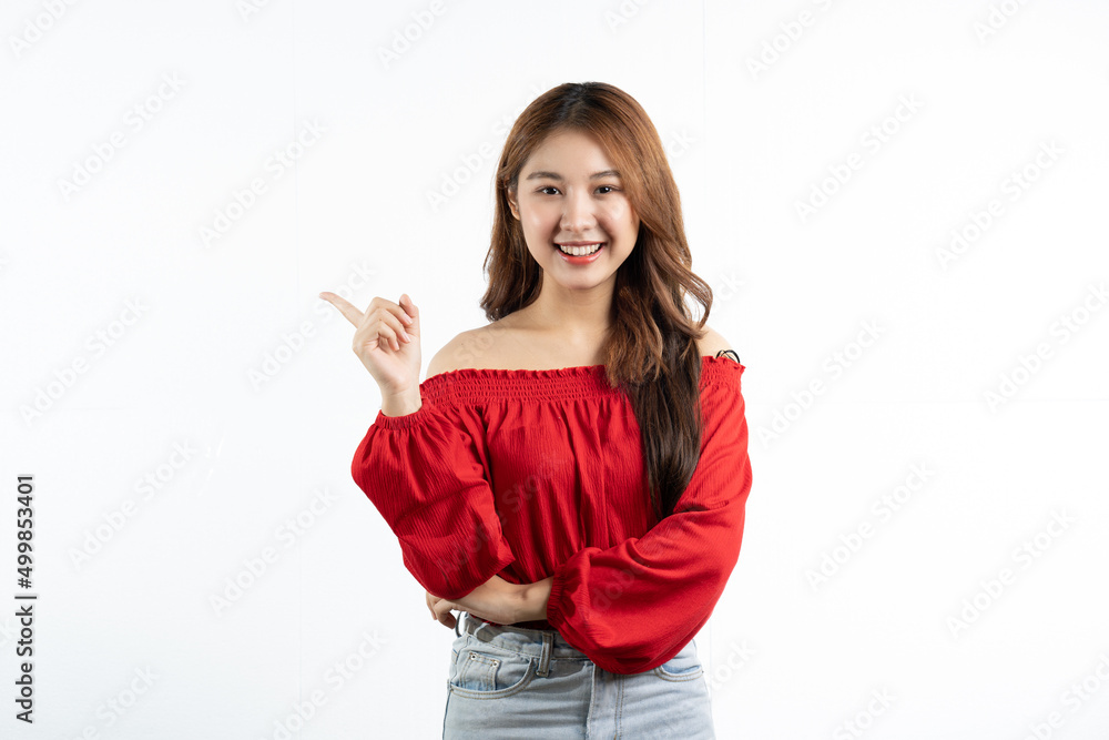 Young elegant beautiful Asian woman smiling and pointing to empty copy space isolated on white background. Young elegant beautiful Asian woman smiling and pointing to empty copy space isolated on white background.