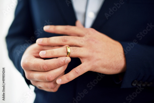 Wedding rings are symbols of commitment, promise and loyalty. Cropped shot of an unrecognizable bridegroom adjusting his ring on his wedding day. © C Malambo/peopleimages.com