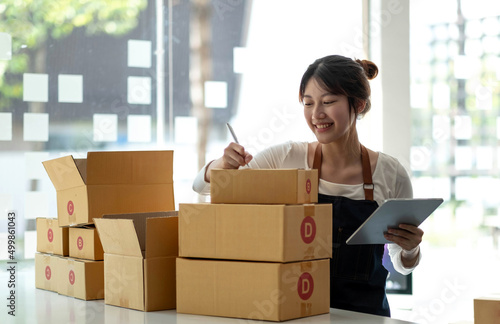 Portrait of Starting small businesses SME owners female entrepreneurs working on receipt box and check online orders to prepare to pack the boxes, sell to customers, sme business ideas online.