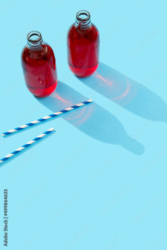 Summer iced cranberrie punch cocktail in bottle on blue background Summer iced cranberrie punch cocktail in bottle on blue background