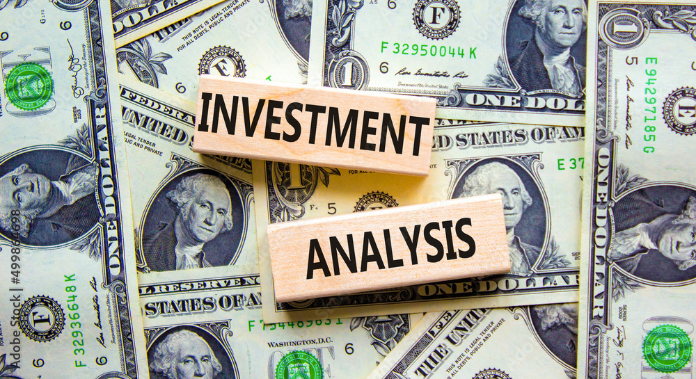 Investment analysis symbol. Wooden blocks with concept words Investment analysis on beautiful background from dollar bills. Business investment analysis concept. Copy space.