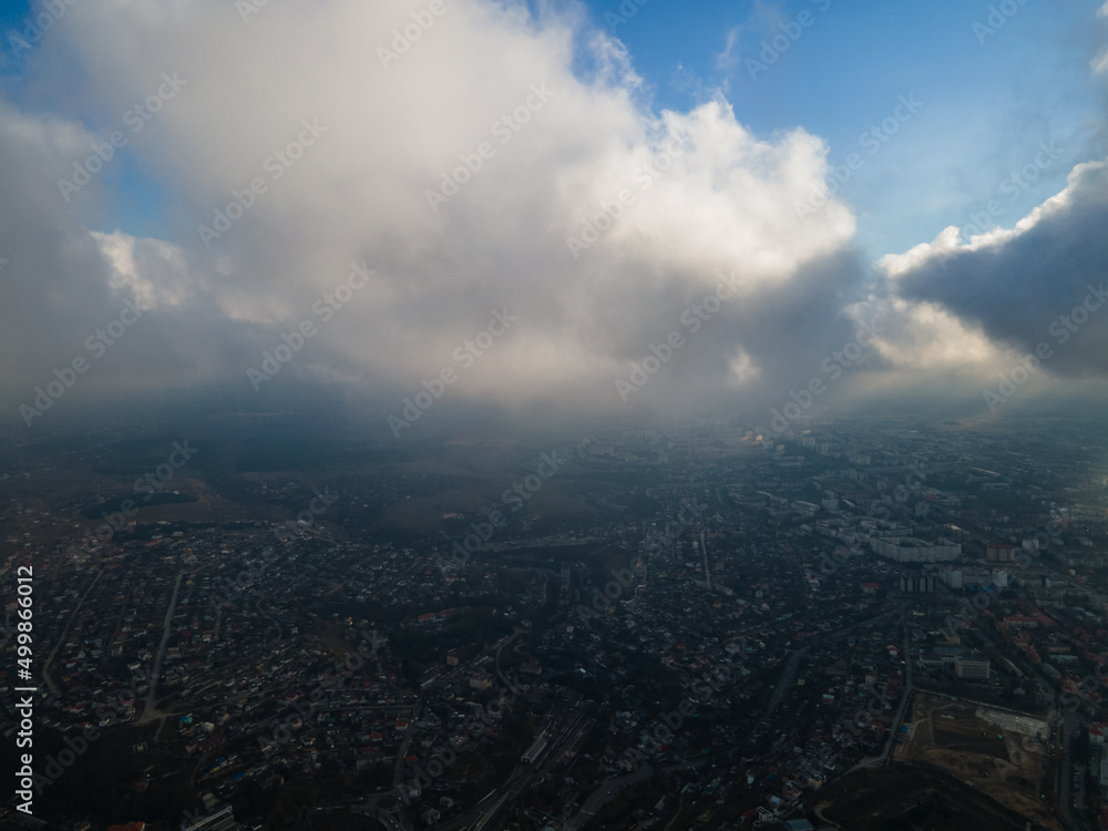 A magical flight in the clouds over the city. The sun's rays are beautifully reflected from the clouds. Above the sky. Fluffy clouds. shooting at high altitude.