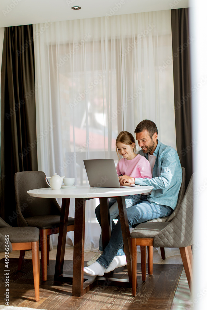 Father and daughter using laptop computer together Father and daughter using laptop computer together