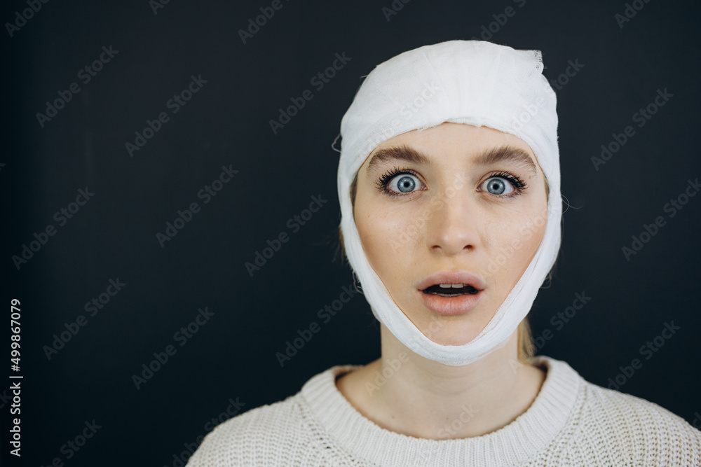 Surprised woman after plastic surgery with a bandage. Beauty, fashion and plastic surgery concept Surprised woman after plastic surgery with a bandage. Beauty, fashion and plastic surgery concept