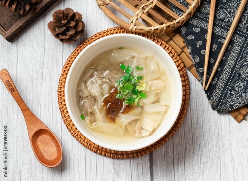 flat food soup in a dish with wooden soup isolated on wood table side view taiwan food photo