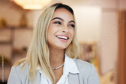 Looking forward to my first customer. Shot of a young businesswoman in her clothing store.