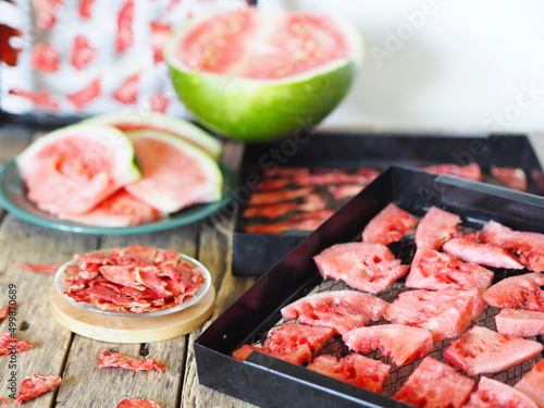 Drying watermelon.The process of preparing sweet treats for future use, from a whole green watermelon to dried slices of homemade dried watermelon fruit on a plate. Fall harvesting season.