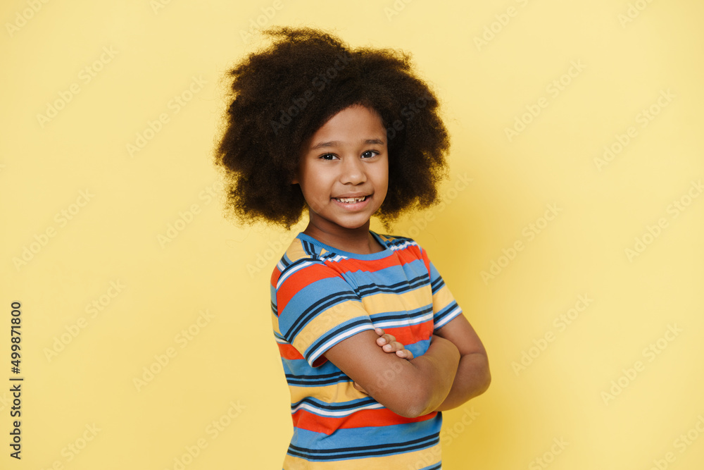 Black preteen girl with curly hair smiling and looking at camera Black preteen girl with curly hair smiling and looking at camera