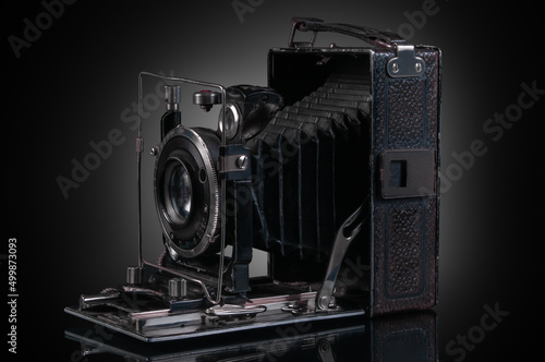 retro folded analog camera on black background with reflection