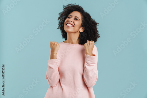 Fototapeta Black young woman laughing while making winner gesture