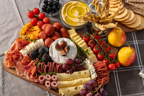 Cured cheese and meze platter rich in variety of fruits, cheese, meat and crackers