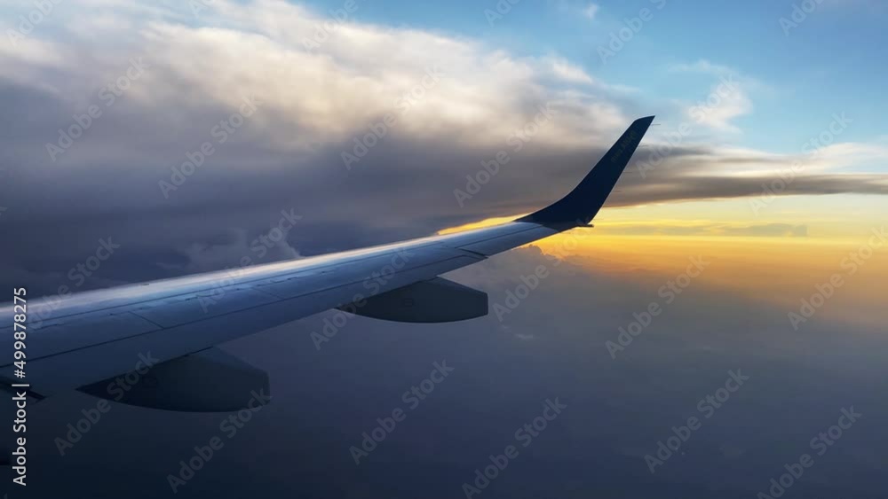 View of the red sunset sky from the window of a passenger plane View of the red sunset sky from the window of a passenger plane