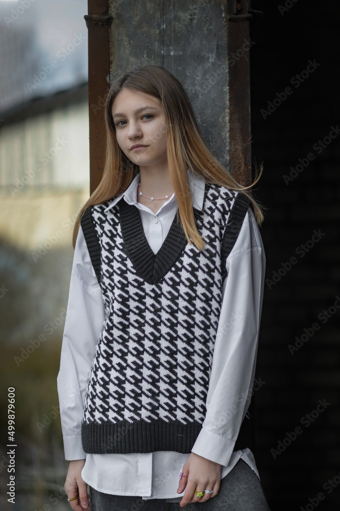 Portrait of a young beautiful girl in a knitted black and white jacket.
