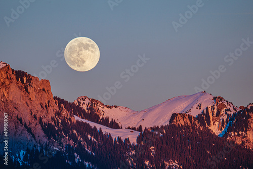 full moon over the snowy mountains