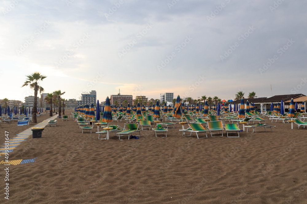 Beach with sunshades and sun beds in seaside resort Sottomarina in Veneto, Italy