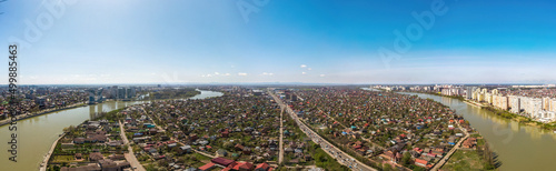large aerial view of the southwestern part of the city center of Krasnodar, the village of Novaya Adygea and the Kuban river near the Turgenev bridge on a spring sunny day.