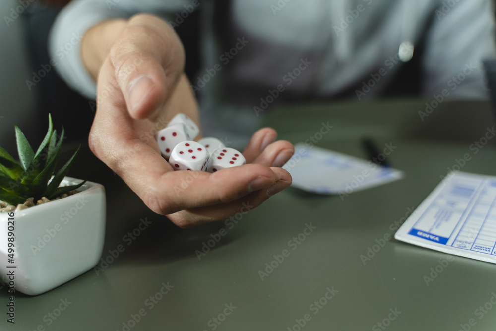 Two friends are playing a board game with dices while arguing and laughing together in a room