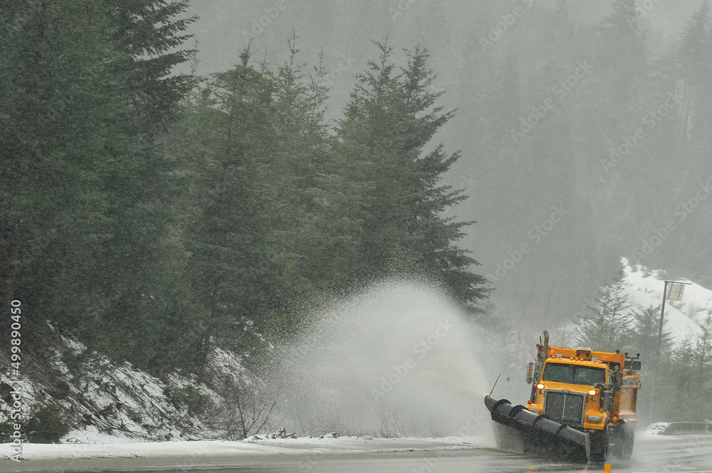 snow plow truck in the snow storm on highway near Hope, British Columbia, Canada snow plow truck in the snow storm on highway near Hope, British Columbia, Canada