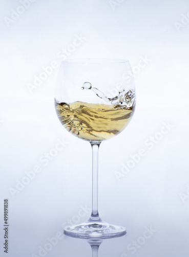  white wine glasses with moving liquid on a greyish-white background
