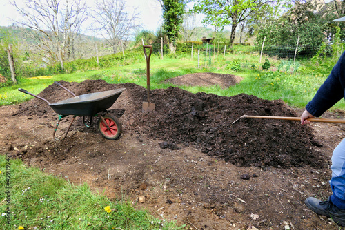 Compost being raked onto the vegetable bed 
