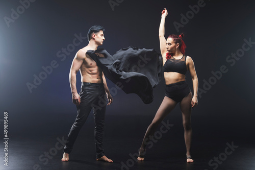 Circus acrobats man and woman showing tricks isolated on black background photo