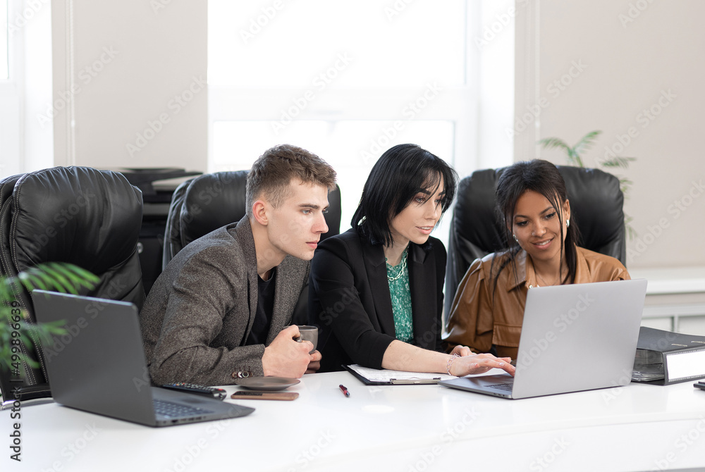 An international group of business people working together in a modern office An international group of business people working together in a modern office