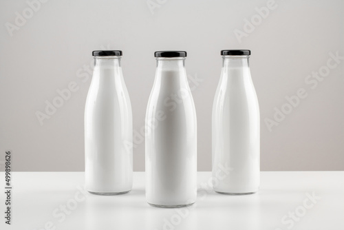 Packaging for dairy products, glass bottles for milk isolated on white background. Unmarked bottles filled with milk.