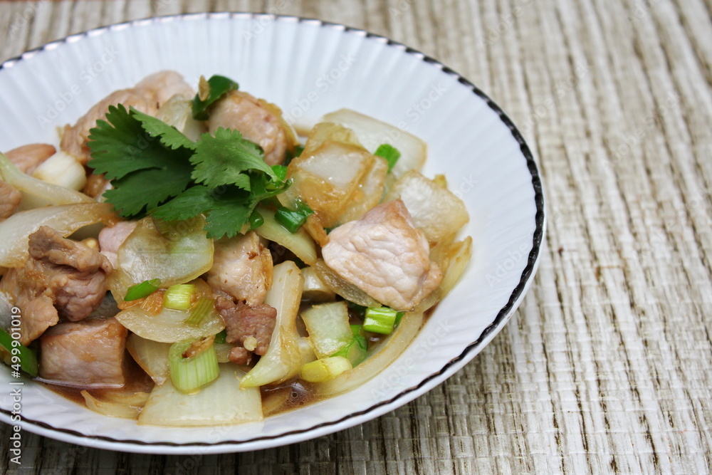 Stir-fried pork with chilli with onions and spring onions served in a white plate, Stir-fried pork with chilli is a popular Thai dish that Thai people eat. Stir-fried pork with chilli with onions and spring onions served in a white plate, Stir-fried pork with chilli is a popular Thai dish that Thai people eat.