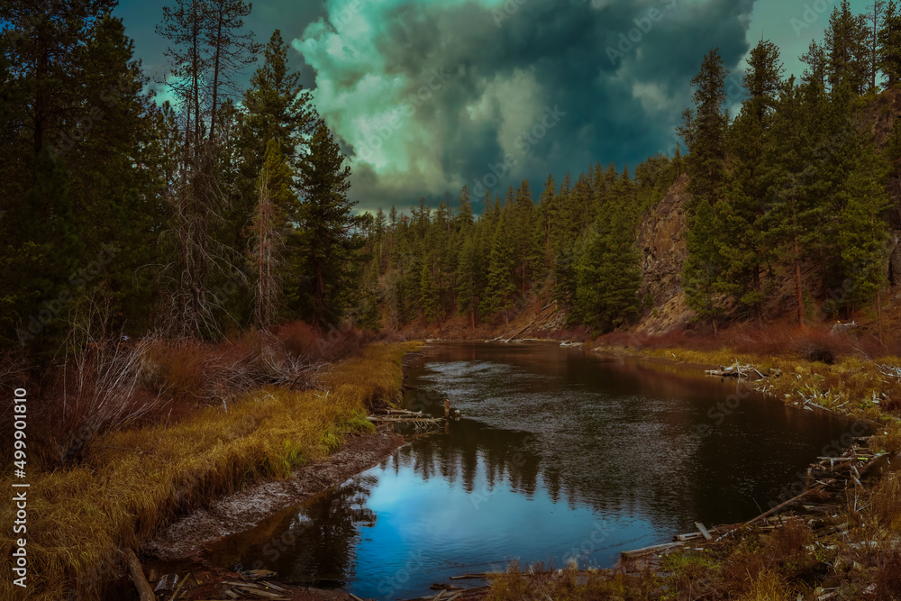 2022-04-19 THE DESCHUTES RIVER LINED WITH EVERGREEN TREES AND A REFLECTION IN THE RIVER AND A CLOUDY SKY 2022-04-19 THE DESCHUTES RIVER LINED WITH EVERGREEN TREES AND A REFLECTION IN THE RIVER AND A CLOUDY SKY