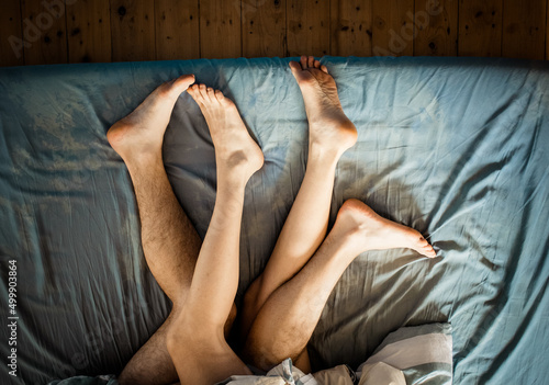 legs of couple in bed making love photo