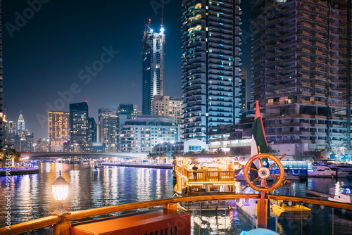 Night Walk On Tourist Boat, Sightseeing Boat Sailing On Dubai Marina. Night View Of Dubai Marina Is District in Dubai, United Arab Emirates.