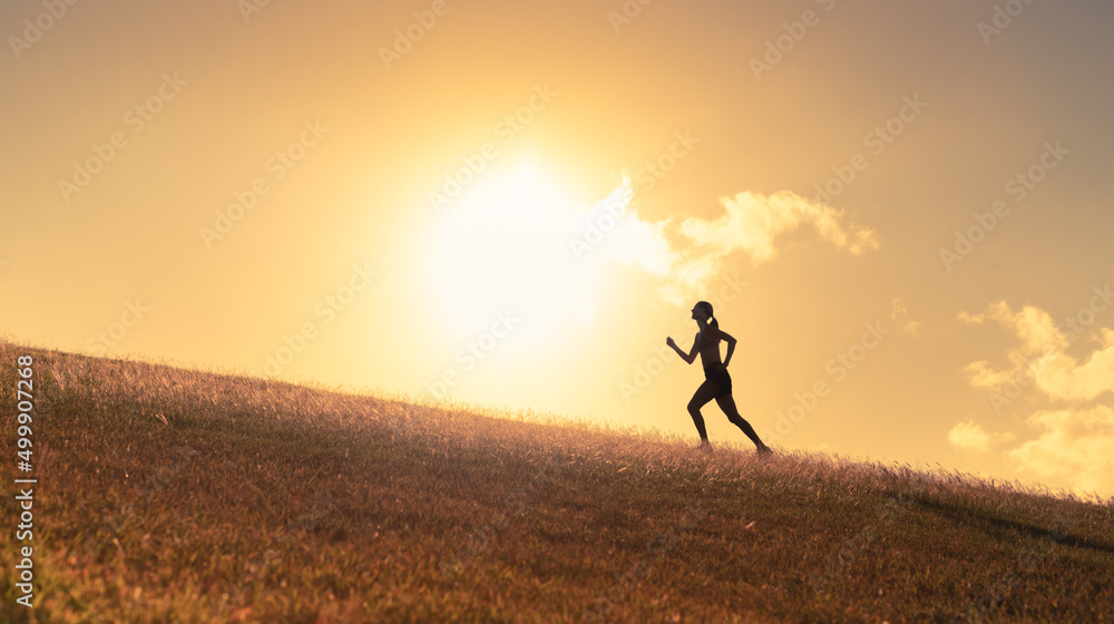 Female runner silhouette running up hill