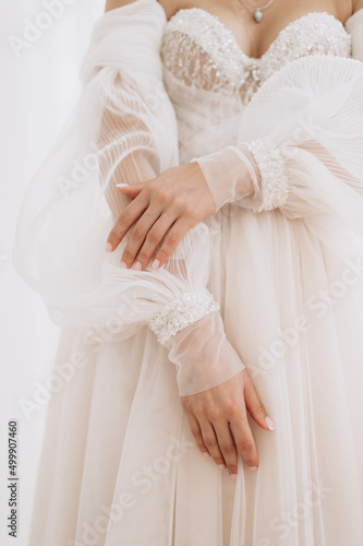 bride in a wedding dress gently touches the ring with her fingers