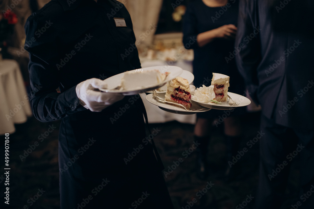 waiter in a restaurant at a banquet with plates and food on a tray