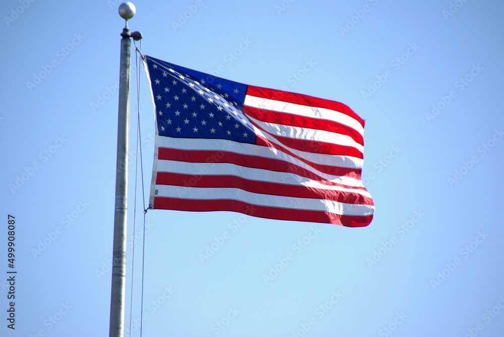 American Flag Waving Against Blue Sky American Flag Waving Against Blue Sky