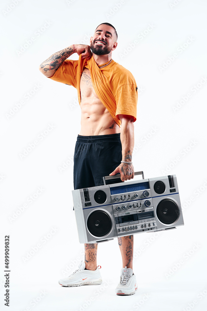 Male model, muscular, strong man, posing with an old school radio, an aggressive expression, showing his strength.