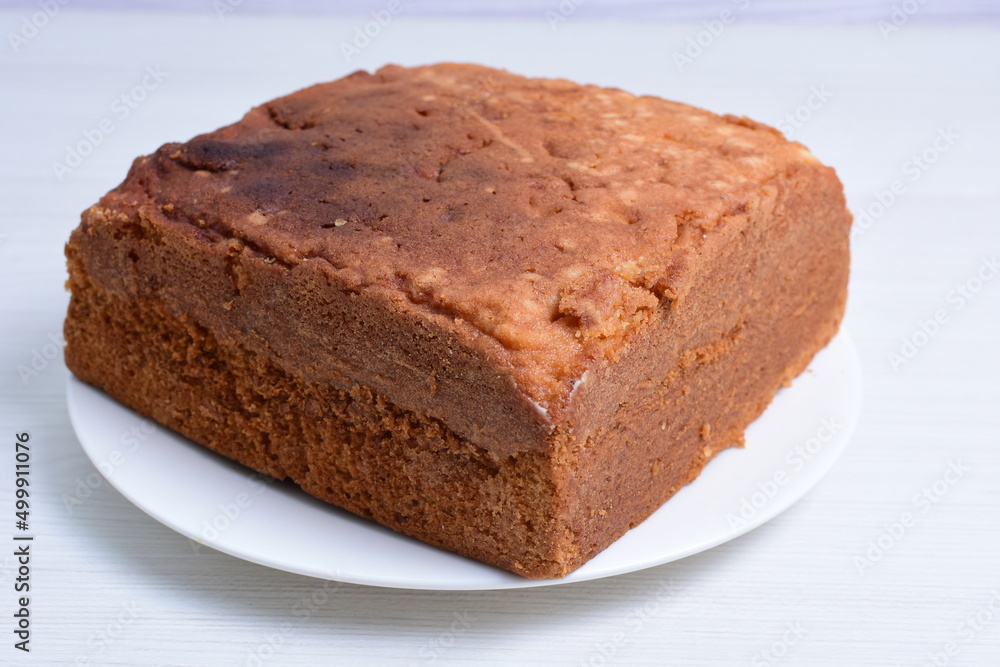 Homemade vanilla cake, displayed on plate and wooden background